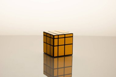 Gold Rubik's Cube on grey background clipart