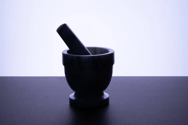 Manual bowl for grinding black pepper dark bottom white background