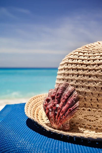Stro hoed met rode shell op een tropisch strand — Stockfoto