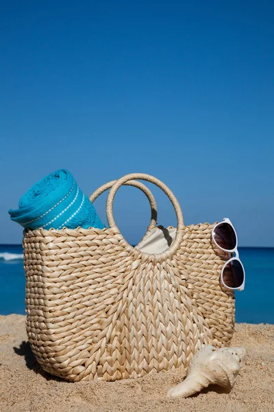 Zomer strooien tas met blauwe handdoek en zonnebril op een tropische sa — Stockfoto