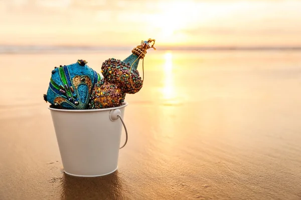 Altın beyaz bir kova içinde mavi Noel süsleri toplanan