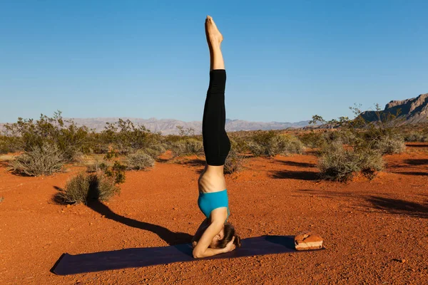 Young woman doing yoga in desert at sunset time