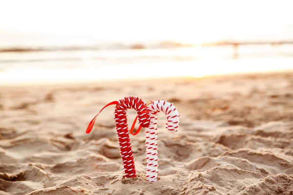 Weihnachten Hintergrund mit Zuckerstangen am Sandstrand bei golden s — Stockfoto