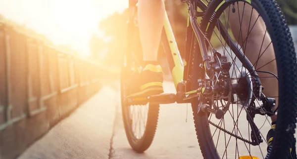 Vista a basso angolo del ciclista in bicicletta sulla strada all'alba, foc morbido — Foto Stock