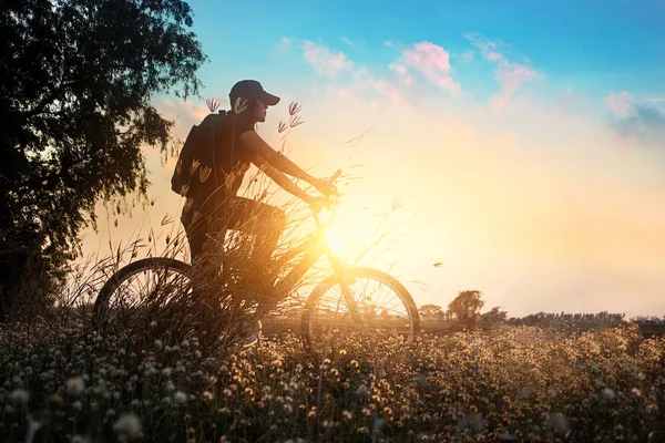Motociclista en bicicleta de montaña aventura en la naturaleza hermosas flores, puesta de sol de verano — Foto de Stock