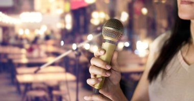 Mikrofon pub ve Restoran arka plan üzerinde elinde tutan kadın