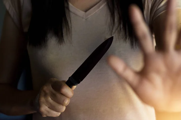 Žena držící nůž v ruce zároveň brání před útokem. — Stock fotografie