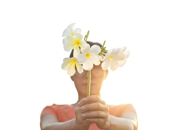 Mujer sosteniendo flores blancas en las manos sobre un fondo claro —  Fotos de Stock