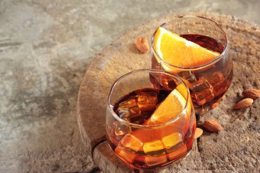 ahşap arka plan üzerinde buz ve turuncu parça ile viski içer