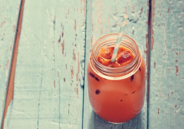 Ahşap arka plan üzerinde buzlu süt çay