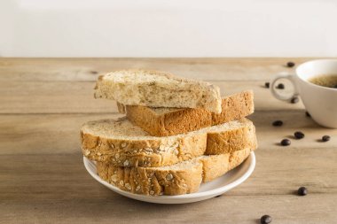 Kepekli ekmek beyaz susam, kahve çekirdekleri ile kahve fincanı wo üzerinde
