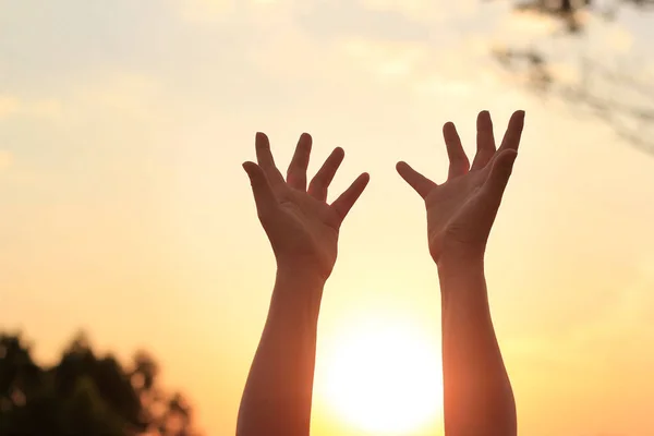 Mulher mãos orando por bênção de Deus no pôr do sol fundo — Fotografia de Stock