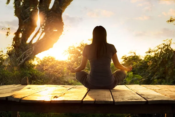 Mujer practicando yoga de meditación sobre la naturaleza al atardecer . — Foto de Stock
