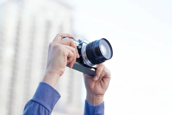 Mujer sosteniendo retro película cámara tomando foto —  Fotos de Stock