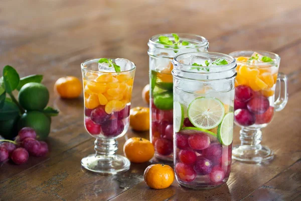 Infused water detox diet drinks of mix fruits on wooden — Stock Photo, Image