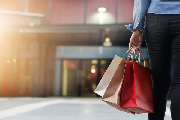 Mulher andando com sacos de compras na mão no shopping center fundo . — Fotografia de Stock