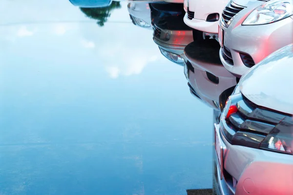 Cars in parking lot and reflection in water — Stock Photo, Image