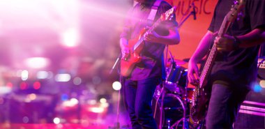 Gitarist ve bir sahnede, yumuşak odak renkli aydınlatma