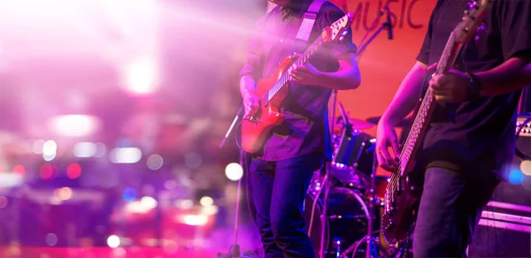 Guitarist and colorful lighting on a stage, soft focus — Stock Photo, Image