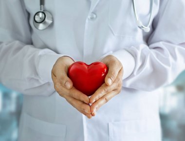 Doktor elinde stetoskop ve kırmızı kalp şeklinde