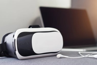 VR mezartaşı ile kulaklık ve kanepe üstünde laptop