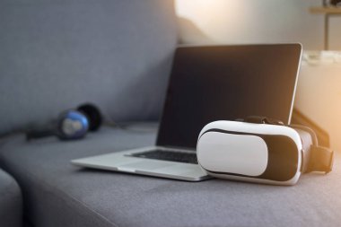 VR mezartaşı ile kulaklık ve kanepe oturma odasında üstünde laptop