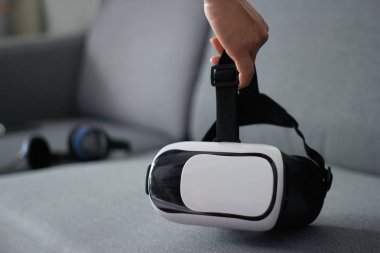 Adam el sanal gerçeklik tutarak kanepenin üzerinde koruyucu gözlük