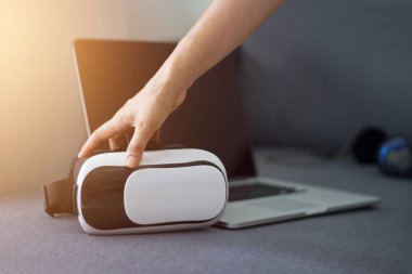 Adam el VR kulaklık kulaklık ve kanepe üstünde laptop ile dokunmak