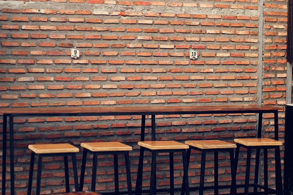 Пустой деревянный стол и стулья для уличной еды на кирпичной стене текстуры — стоковое фото