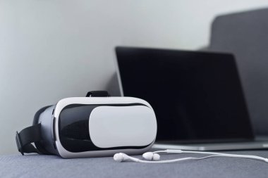 VR mezartaşı ile kulaklık ve kanepe oturma odası üstünde laptop