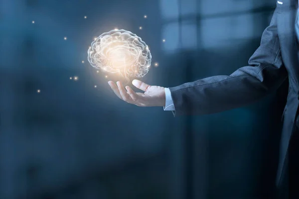 Businessman holding virsual brain and stardust in hand — Stock Photo, Image