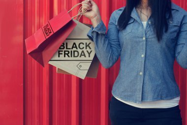 Black Friday alışveriş torbaları kırmızı bana süre ayakta tutan kadın