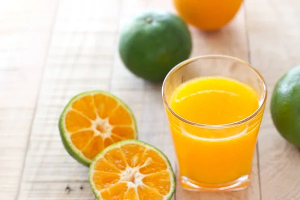 木制背景的新鲜橙汁 — 图库照片