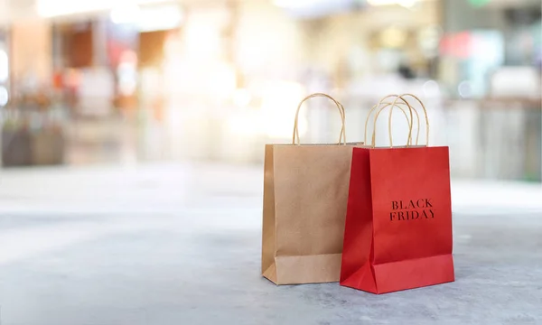 Venerdì nero shopping bags sul pavimento all'aperto con sfondo centro commerciale — Foto Stock