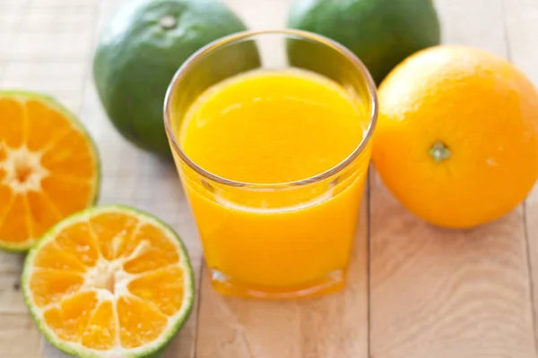 Fresh orange juice on wooden background — Stock Photo, Image
