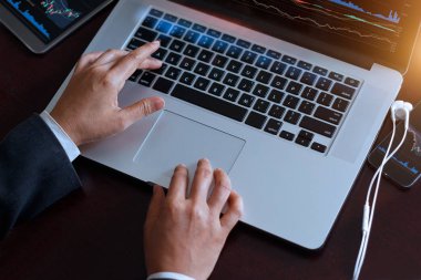 Borsa grafik ekran üzerinde çalışan dizüstü kullanarak iş adamı