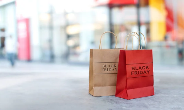 Preto sexta-feira venda sacos de compras no chão frente do shopping store fundo — Fotografia de Stock