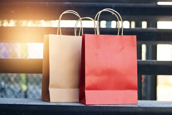 Sacos de compras de papel vermelho e marrom colocados em escadas ao ar livre — Fotografia de Stock