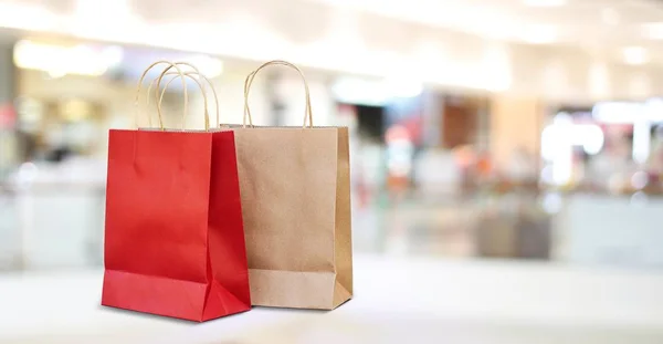 Borse shopping rosse e marroni sullo sfondo del negozio del centro commerciale — Foto Stock