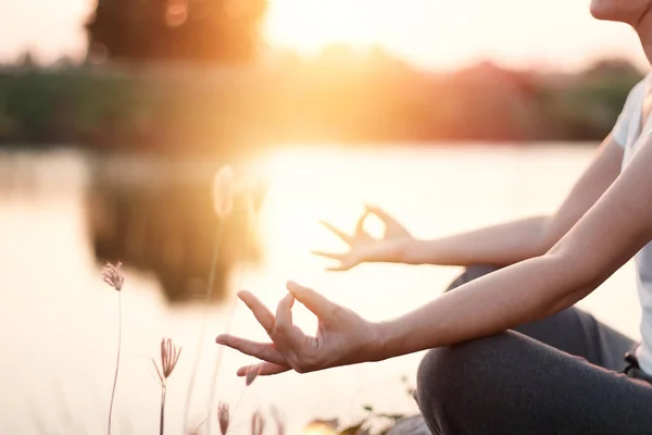 Mulher ioga praticando e meditando junto ao lago em fundo de verão — Fotografia de Stock