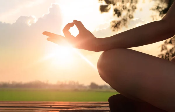 Mujer meditando en la puesta del sol fondo al aire libre —  Fotos de Stock