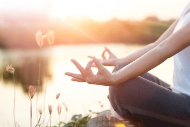 Kadın yoga uygulamak ve yaz aylarında göl kenarında meditasyon