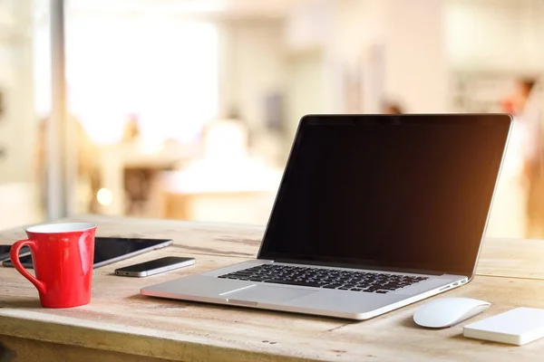 Laptop met leeg zwart scherm op tafel in de coffeeshop achtergrond — Stockfoto
