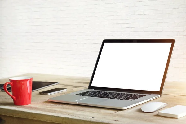 Laptop met leeg wit scherm op tafel in witte bakstenen muur achtergrond — Stockfoto