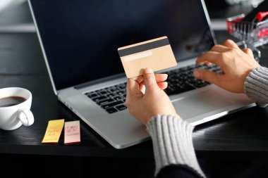 Alışveriş online kavramı. Altın kredi kartı dizüstü evde kullanarak online alışveriş için elinde tutan kadın
