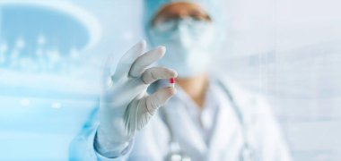 Bir renk kapsül pill laboratuvar beyaz eldiven ile elinde tutan tıp doktor 