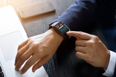 Dizüstü bilgisayar ve çalışma tablo, teknoloji ve iletişim kavramı smartphone akıllı izle app kullanarak işadamı eller. 