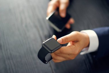Smartphone ile işadamı eşitleme, çift veya maç smartwatch closeup