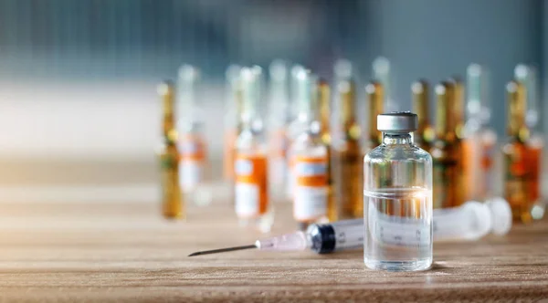 A bottle of vaccine biological provides immunity to a disease and  syringe on medicine background. — Stock Photo, Image