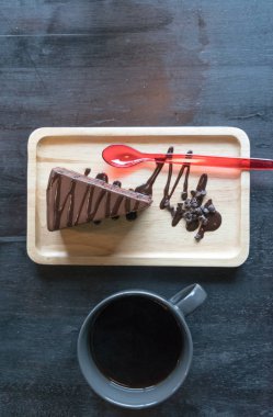 Siyah kahve ile ahşap plaka üzerinde kek dizi Üstten Görünüm